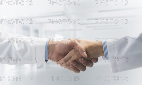 Close-up of the handshake between the two medics. Against the backdrop of the cityscape
