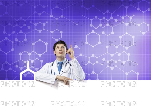 Young handsome doctor holding white blank banner. Place your text