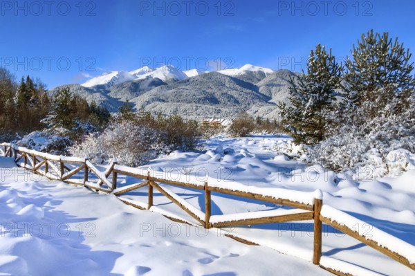 Travel winter rural mountain landscape panoramic view, trees and fence covered with snow