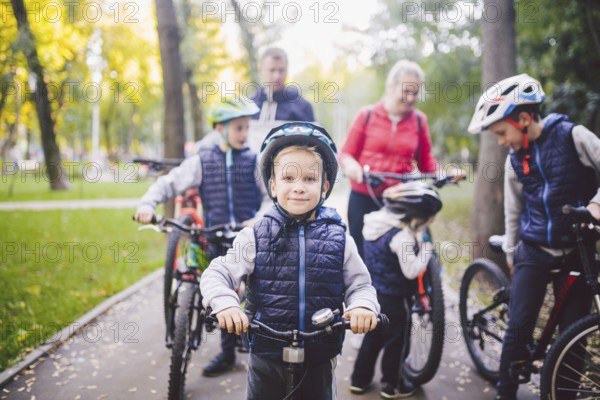 Theme family sports holiday in park in nature. big friendly Caucasian family of six people mountain bike riding in forest. Children brothers and sister stand on the background of parents in a row