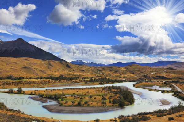 Beautiful summer morning in Patagonia. Island in the middle of the river and the snow-capped mountains illuminated by the sun