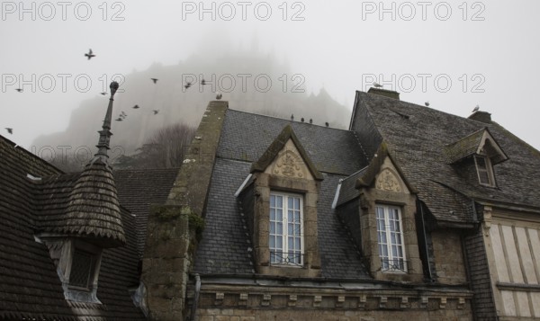 Mont-Saint-Michel, monastery hill, Grand Rue, roofscape above the abbey in the mist