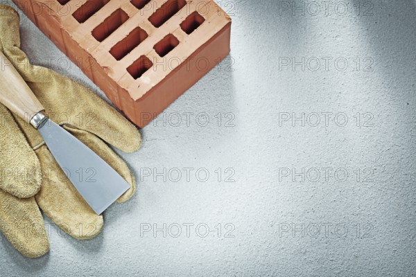 Building bricks leather safety gloves paint scraper on concrete background bricklaying concept