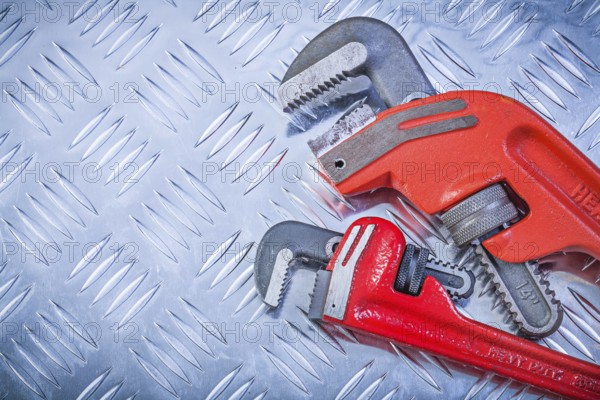 Set of pipe wrenches on fluted metal plate construction concept