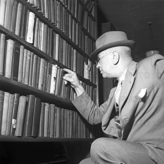 United Kingdom 1945. The village of Tylorstown in the Rhondda valley in Wales. Tylorstown was founded in the mid-19th century as a result of the coal mining at the location. Pictured here a man at the local library, choosing a book in the bookshelf. By swedish photographer KG Kristoffersson who was in Great Britain 1945. ref S99-1