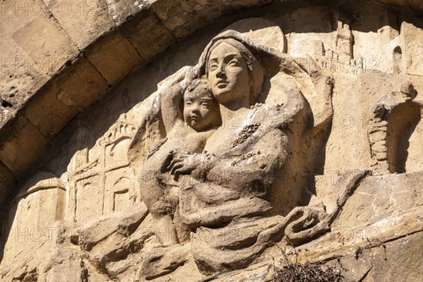 An old baroque engraved sculpture of Mary and Jesus over an entrance to the Cappella della Croce di Giorno in VolterraCappella della Croce di Giorno