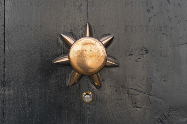 Closeup of a copper doorknob with a small peephole under it