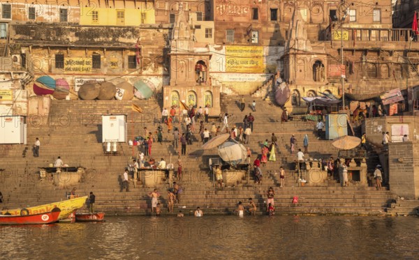 Varanasi, India, March 13 2017: India people at the ghats and riverbank of sacred Ganges river for bathing early in the morning