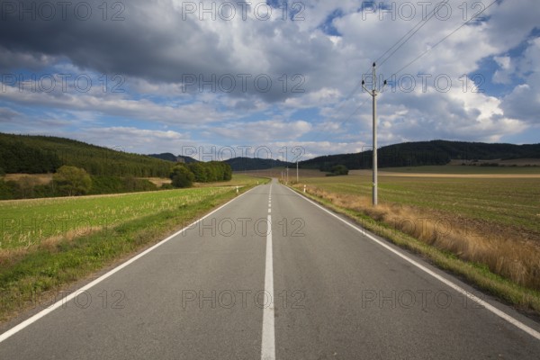 On the empty road between summer field