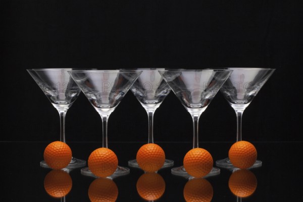 Five glasses of champagne with golf balls