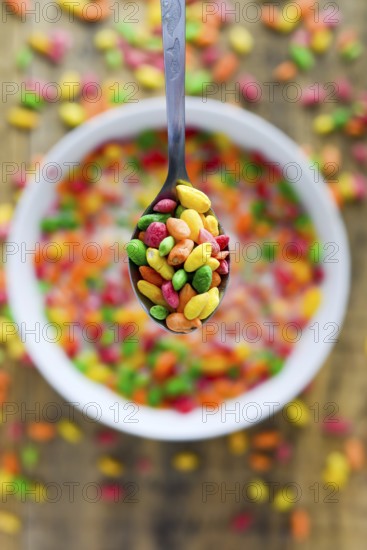 Spoon with colorful rice in the milk with blured background. Selective focus