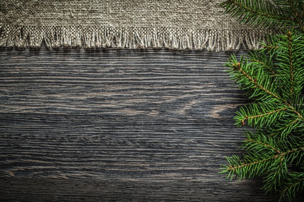 Vintage sackcloth pine branch on wooden board Christmas background