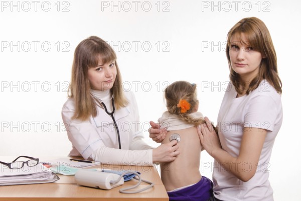 Pediatrician listening stethoscope baby's back, which keeps mum