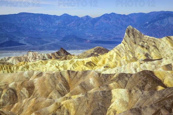 Zabriskie Point is part of the Amargosa Range. Death Valley in California, USA. Magnificent erosion landscape of various shades. Sunset. The concept of active, extreme and photo tourism