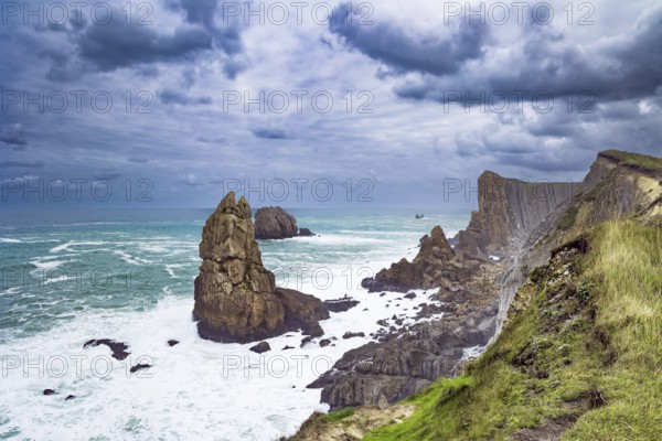Powerful surf waves with a foam crest. Cantabria. Windy stormy day on the Atlantic coast. Rocky picturesque ocean coast. The beach of Playa di Arnia, Spain