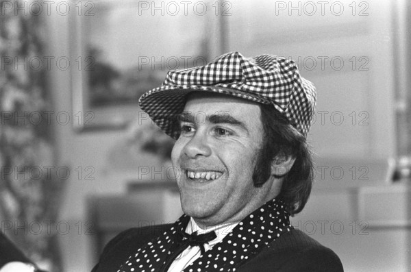 Elton John. English singer, songwriter born march 25 1947. Pictured wearing a chequered cap and a matching chequered scarf during a visit to Sweden 1978