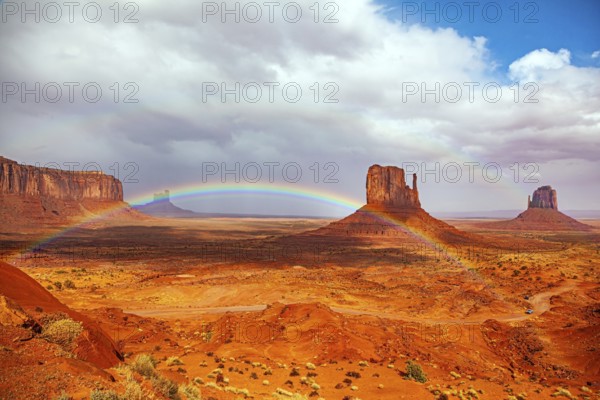 The bright rainbow all over the sky. Monument Valley is a unique geological formation in Arizona and Utah. The famous rock Mitten. USA. Navajo Indian Reservations