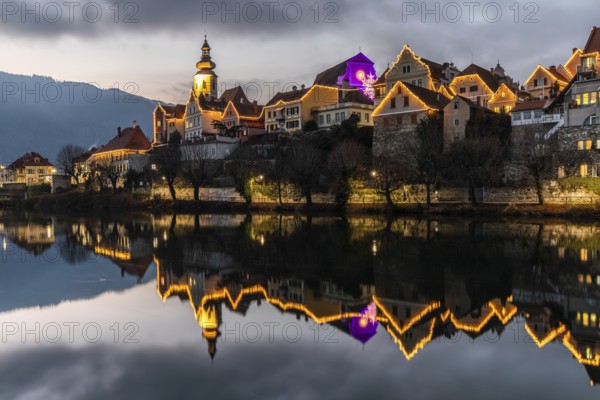 Christmas illuminated house facade of Frohnleiten reflected in the river Mur, Frohnleiten, Styria, Austria
