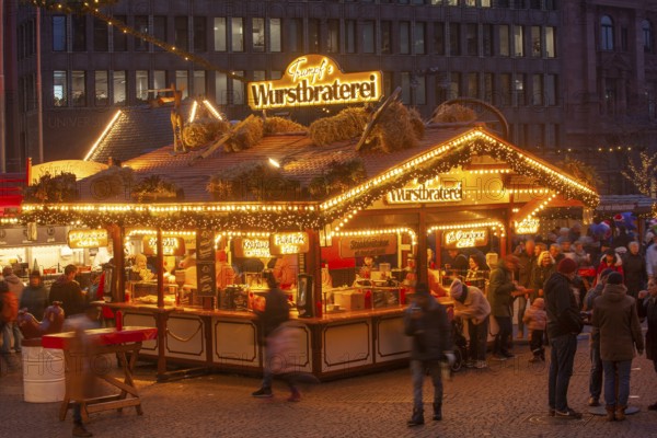 Sausage roasting stand with many people at the Bremen Christmas market at dusk, Bremen, Germany
