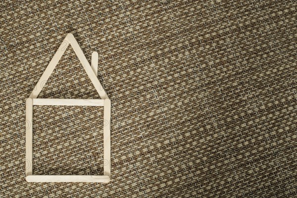 Model house made of wooden sticks placed in room interior