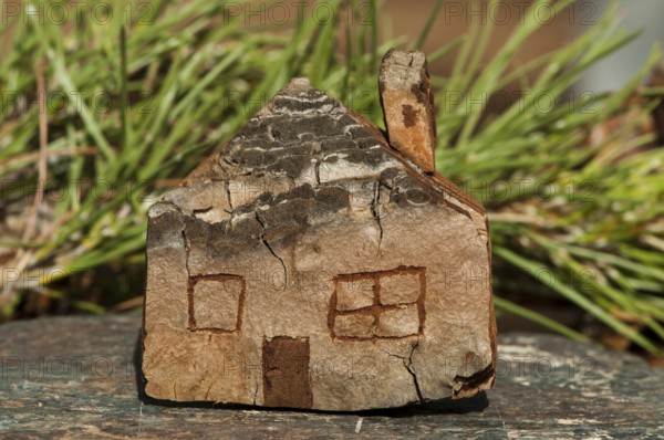 Model of a small wooden house. Green natural background
