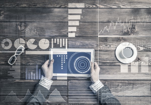 Business workplace with tablet device on wooden surface and media interface