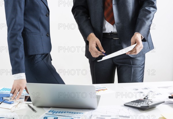 Corporate teamwork concept with businessman. Business people meeting in conference room. Idea presentation and analyze. Office desk with financial charts and laptop. Collaboration and conversation