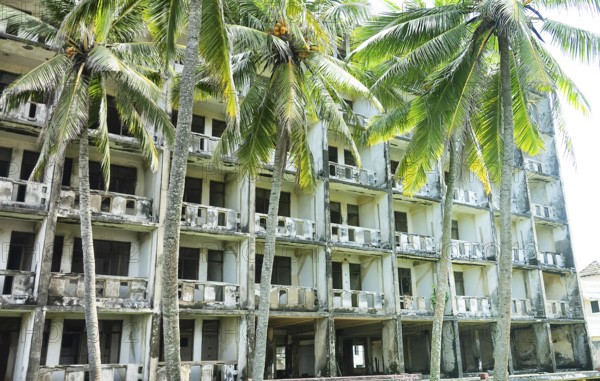 Abandoned hotel in coastal recreation area in Southeast Asia. Palm trees and failed otel business