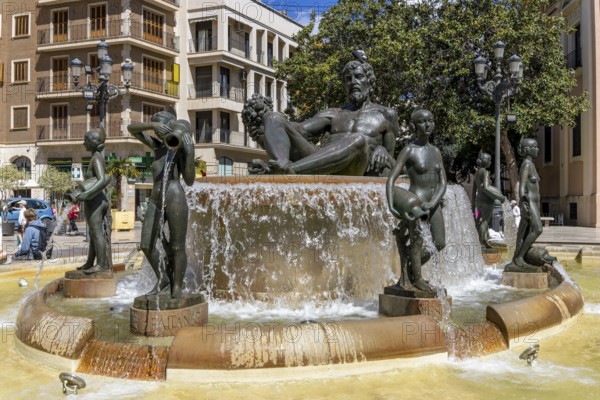 Turia Fountain (Font Del Túria) with a large sculpture of the Turia Man in the centre, surrounded by many female sculptures in the Plaça de la Mare de Déu in the old town, Valencia, Autonomous Community of Valencia, province of Valencia, Spain
