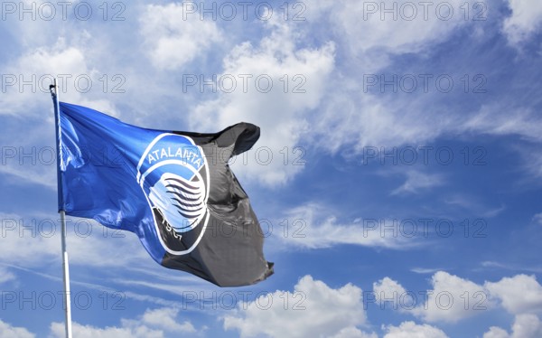 Atalanta flag waving against blue sky with white clouds. Space for text. Bergamo, ITALY - December 10, 2018