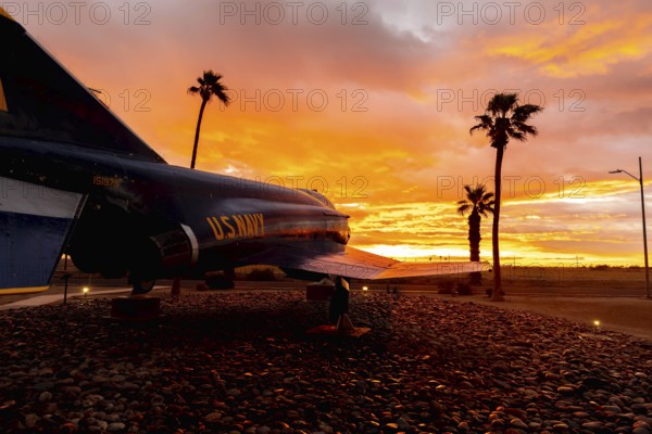 Dawn at Naval Air Field El Centro, CA: Sunlight paints vibrant hues across the sky, casting a mesmerizing rainbow over parked aircraft, creating a breathtaking spectacle