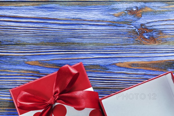 Red packed present box on vintage wooden board