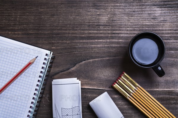 Notepad pencil construction drawings wooden meter and cup of coffee on wood board maintenance concept