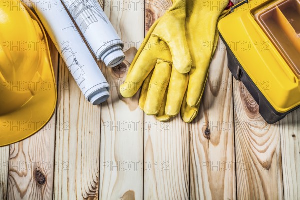 Blueprints helmet gloves and tool box on wood