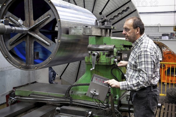 An older employee in the metal industry works on a CNC milling machine, Senior, 65, years, toolmaker, occupation, professions, metal industry Vienna, Austria