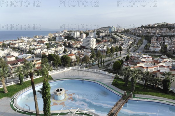 On the way to Ephesus, Lycia, view of urban landscape with swimming pool and palm trees, surrounded by buildings, Antalya Province, Turkey
