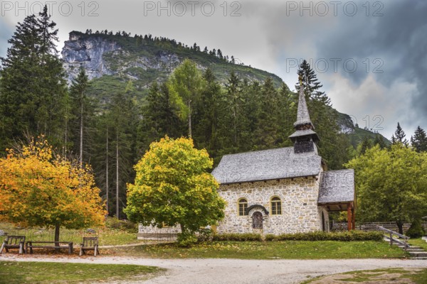 Church on the Alpine lake Lago di Braies. The concept of walking and eco-tourism. Travel to the Southern Tyrol, Italy