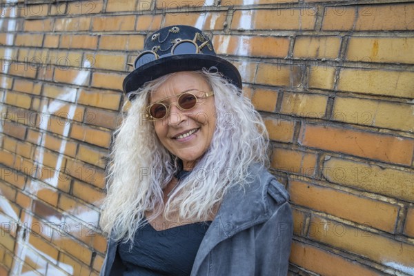 Schöne Steam Punk Lady steht auf einer Backsteinmauer Hintergrund