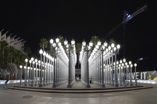A picture of Urban Light, a public art designed by Chris Burden and unveiled in 2008, next to the Los Angeles County Museum of Art, at night