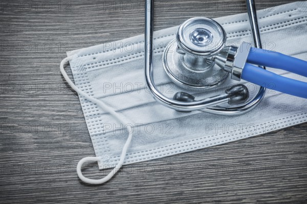 Disposable face mask stethoscope on wooden board