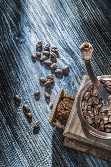 Coffee grinder beans on vintage wooden board