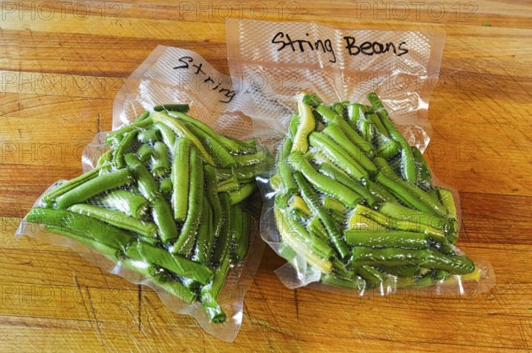 Two packages of fresh green beans vacuum sealed into bags