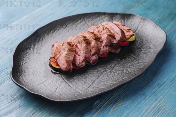 Fried pork on eggplant on black plate