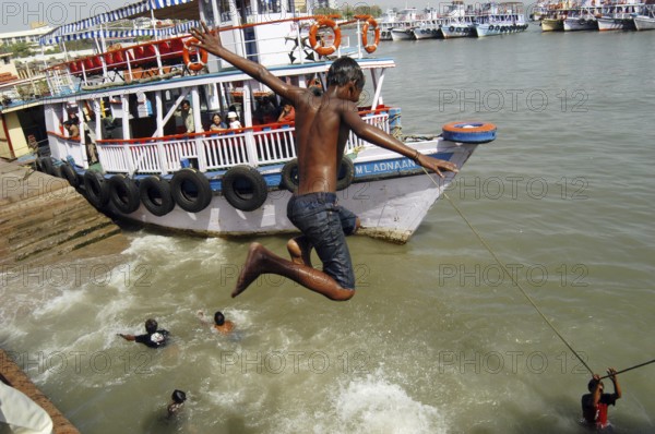 Children jumping and swimming into the Arabian Sea at Gateway of India, Bombay now Mumbai, Maharashtra, India