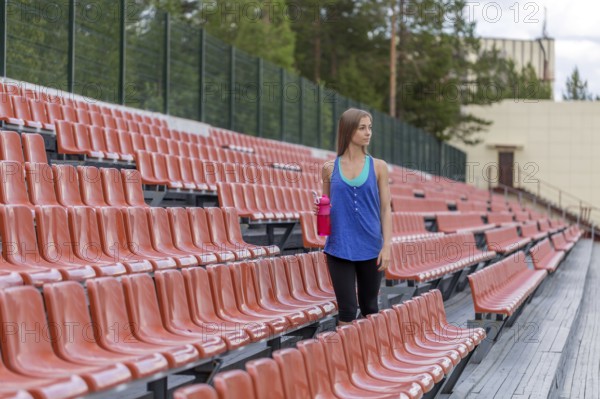Girl with a bottle of pink at the stadium