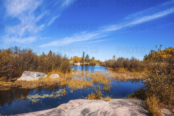 Old Pinawa Dam Provincial Heritage Park. Warm day. Yellow autumn grass is reflected in the Winnipeg River. The concept of ecological and recreational tourism