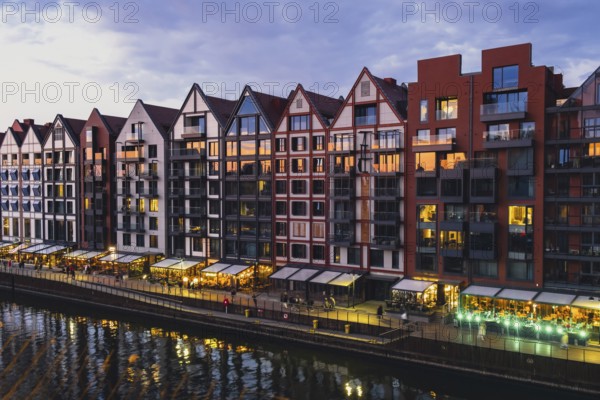 Old town in Gdansk at summer dusk Poland. Sunset night view from the window rooftop on new modern architecture buildings Hotels to stay in Gdansk Place to eat over Motlawa river Wyspa Spichrzow Travel attraction