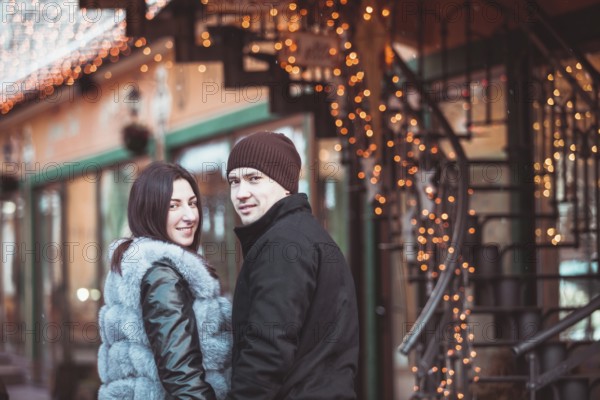 Romantic couple walking in the winter under the snow in Christmas time