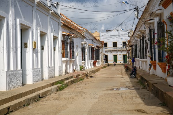 Typical street with white historic buildings in sun and shadow of Santa Cruz de Mompox, Colombia, World Heritage