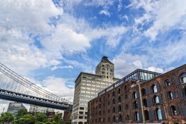 New York City, USA, June 24, 2018: Waterfront of DUMBO area in Brooklyn. Down Under the Manhattan Bridge Overpass. View Against Blue Sky during Summer